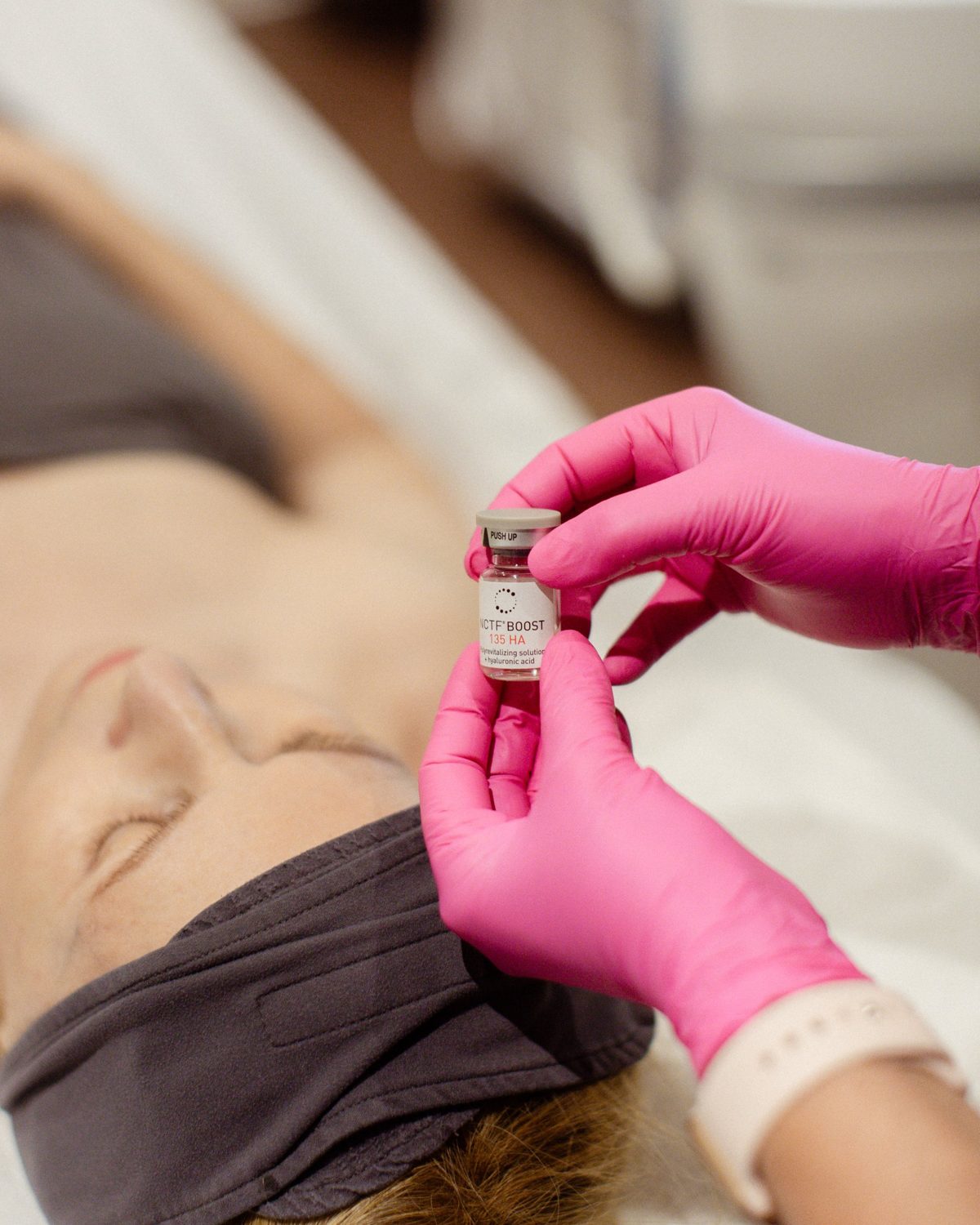 Technicienne présentant une fiole de booster NCTF 135 HA avant un soin du visage à la Clinique Dermarea, Mirabel